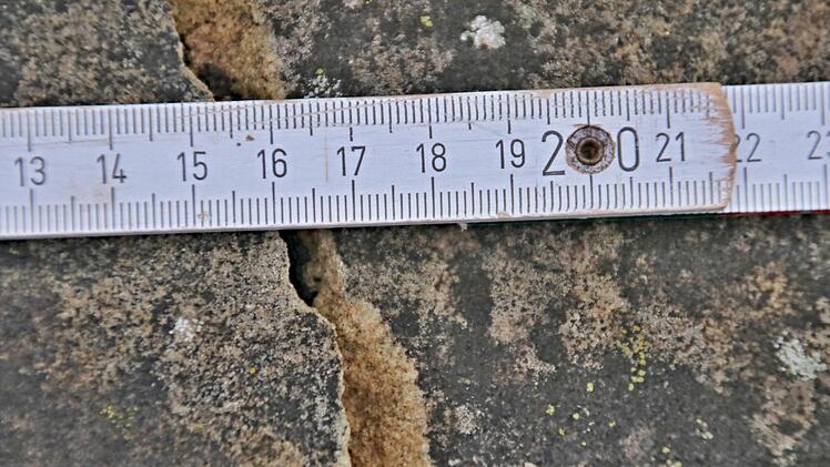 Die Bruchstelle  an der Grabeinfassung ist deutlich zu erkennen.