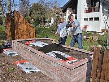 Gisela und Günter Gütlein beim Gestalten ihres Hochbeetes, welches eine dauerhafte Einrichtung in ihrem Garten bleiben wird.  Foto: Helmut Will