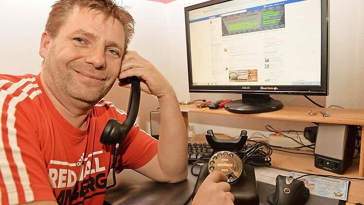 Alte und neue Technik beieinander: Harald Müller mit dem schwarzen Wählscheiben-Telefon, das er über seine eigene Facebookgruppe für fünf Euro gekauft hat. Foto: Ronald Rinklef