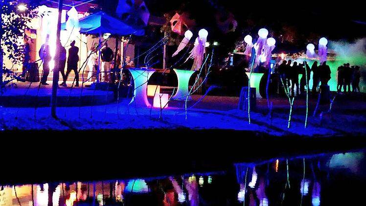 Im bunt illuminierten Eingangsbereich des Badesees feierten die Besucher in der Vollmond-Nacht den Abschluss der Sommersaison. Foto: Dieter Hübner