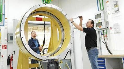 Auch tonnenschwere Großlager gelangen über eine eigens konzipierte Krananlage ins Innere des Akustikzentrums und können dort untersucht werden. Fahrzeugprüfstand: Hier können Fahrzeuge bis zur Größe eines Lieferwagens geräuschtechnisch untersucht werden. Eröffnungszeremonie: Gemeinsam durchschnitten Prof. Peter Pleus, Bereichsvorstand Automotive (rechts), Arbogast Grunau (Mitte) und Alfred Pecher im Rahmen einer kleinen Feierstunde das grüne Band am Eingang zu den neuen Räumlichkeiten. Fotos:...