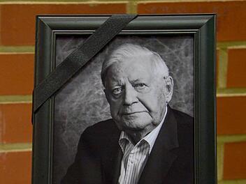 Ein Porträt des am 10.11.2015 verstorbenen früheren Bundeskanzlers Helmut Schmidt (SPD) mit Trauerflor steht am 11.11.2015 im Landtag in Hannover (Niedersachsen) hinter einem Kondolenzbuch. Foto: Peter Steffen/dpa
