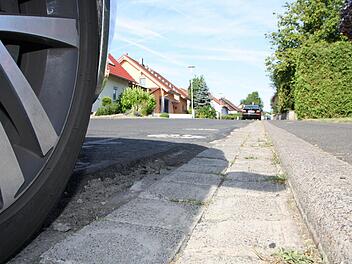 Nicht nur die Schlaglöcher in der Straße, sondern auch die gepflasterte Rinne gehören in der Ortsdurchfahrt Rottershausen bald der Vergangenheit an: Der Landkreis erneuert den Abschnitt der Kreisstraße KG 8, dabei wird ohne Pflaster bis zum Bordstein asphaltiert. Foto: Ralf Ruppert