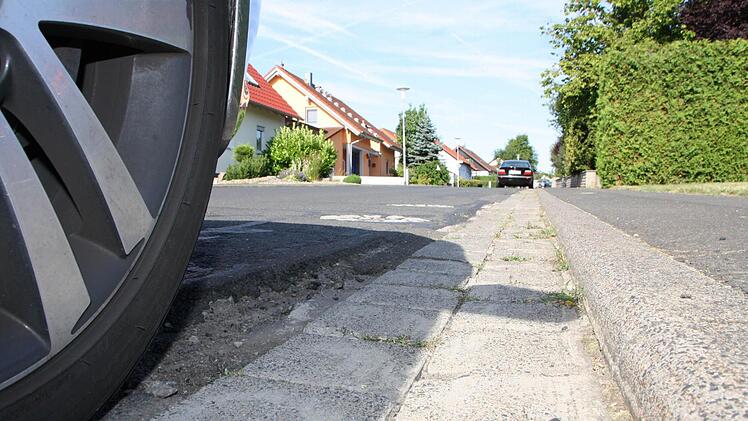 Nicht nur die Schlaglöcher in der Straße, sondern auch die gepflasterte Rinne gehören in der Ortsdurchfahrt Rottershausen bald der Vergangenheit an: Der Landkreis erneuert den Abschnitt der Kreisstraße KG 8, dabei wird ohne Pflaster bis zum Bordstein asphaltiert. Foto: Ralf Ruppert