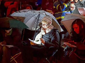 Regenschirm, Klappstuhl, Taschenlampe: So ausgerüstet verfolgten diese Besucherinnen die ökumenische Christvesper im Innenhof der Ehrenburg.