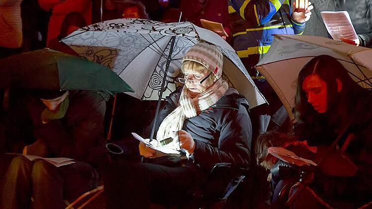 Regenschirm, Klappstuhl, Taschenlampe: So ausgerüstet verfolgten diese Besucherinnen die ökumenische Christvesper im Innenhof der Ehrenburg.