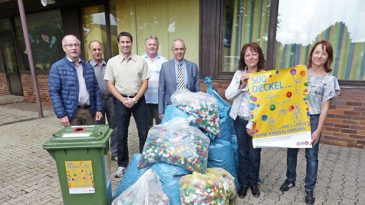 Kerstin Pittroff und Anja Vogel (von rechts) stellten das Plakat des Kronacher "500 Deckel"-Projekts vor, das auch im Landkreis Kulmbach Schule machen soll. In Marktleugast wurden schon mal Tausende Plastikdeckel gesammelt, die (von links) Siegfried Sesselmann, Günther Nohynek, Marc Hartenberger, Klaus Stengl und Bürgermeister Franz Uome verluden. Foto: Klaus-Peter Wulf