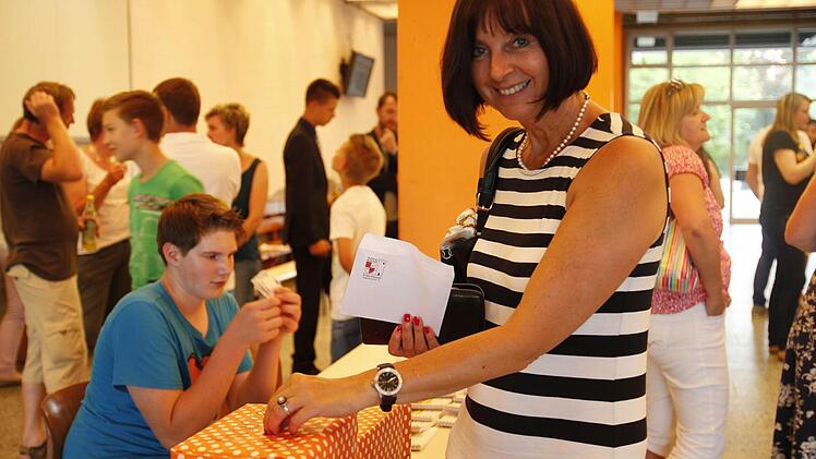 Sichtlich erfreut übe die Wertsteigerung ihrer Aktie ist hier Marion Gießmann, Sekretärin an der Schule, die hier auch die Spendenaktion der Schüler von ihrem Reingewinn unterstützt. Foto: Günther Geiling