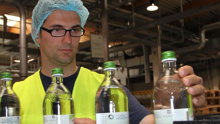 Kontrolle nach der Abfüllung: Andreas Zink, Produktionsleiter bei der Staatlichen Mineralbrunnen AG, hat ein Auge auf die Glasgebinde, die demnächst auf den Markt kommen. Foto: Ulrike Müller