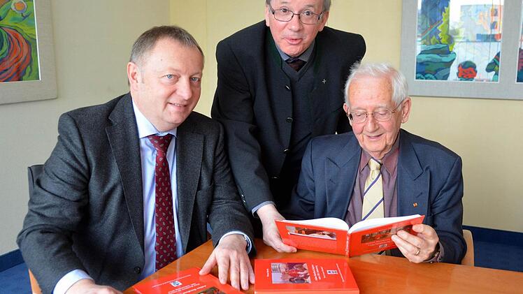 Landrat Thomas Bold (links) und Stadtpfarrer Thomas Keßler (Mitte) nahmen Einblick in Werner Eberths neues Werk "Julius Kardinal Döpfner - Eine Nachlese zu seinem 100. Geburtstag 2013".  Foto: Peter Rauch