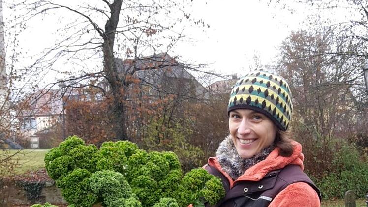 Solawi-Vorsitzende Stefanie Blumers freut sich über einen prächtigen Grünkohl.