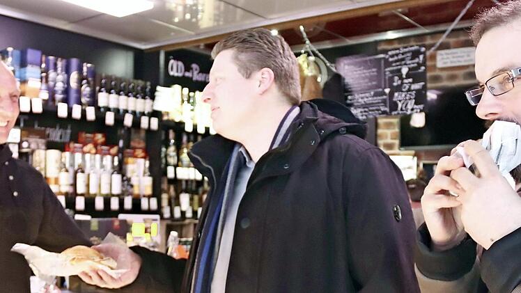 Jürgen Fleischmann versorgt Christian Jakobs und Gerhard Lang (v. l.) mit Wurst- und Fleischwaren. Foto: Johanna Blum