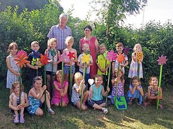 Die "Großen" des Kindergartens St. Pancratius Steinberg freuen sich mit Kita-Leiterin Doris Haderlein über die von Johannes Bühler angefertigten Holzblumen. Aufgestellt in einem "blühenden" Feld im Kita-Garten, sollen sie diese an ihre Kindergarten-Zeit erinnern. Foto: Heike Schülein