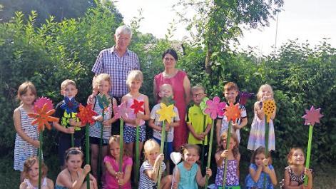 Die "Großen" des Kindergartens St. Pancratius Steinberg freuen sich mit Kita-Leiterin Doris Haderlein über die von Johannes Bühler angefertigten Holzblumen. Aufgestellt in einem "blühenden" Feld im Kita-Garten, sollen sie diese an ihre Kindergarten-Zeit erinnern. Foto: Heike Schülein