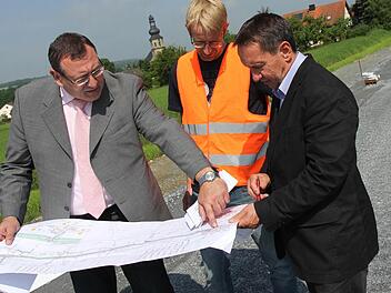 Siegfried Beck vom Bauamt, Jörg Döhler von der Baufirma Rädlinger und Bürgermeister Norbert Gräbner (von links) an der Baustelle bei Seibelsdorf. Im Hintergrund wird am neuen Gehweg gearbeitet.