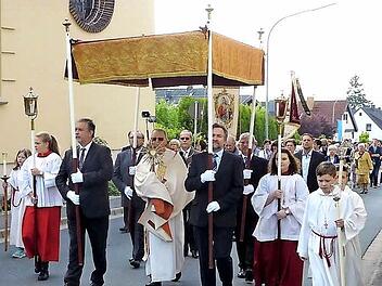 Diakon Wolfgang Fehn trug das Allerheiligste durch die festlich geschmückte Bergwerksgemeinde Stockheim.  Foto: Gerd Fleischmann