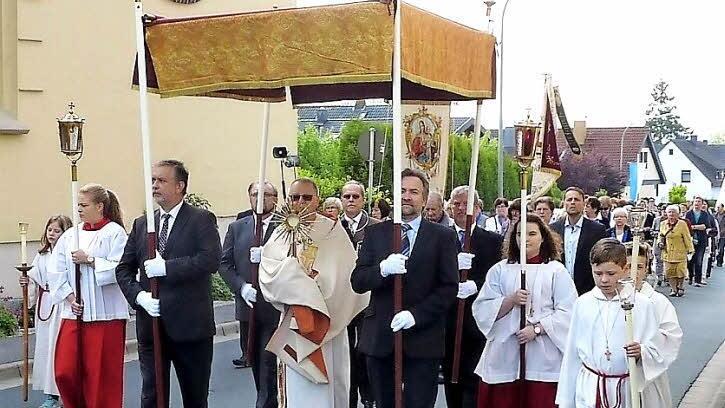 Diakon Wolfgang Fehn trug das Allerheiligste durch die festlich geschmückte Bergwerksgemeinde Stockheim.  Foto: Gerd Fleischmann