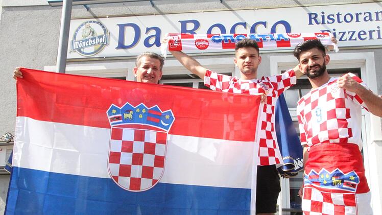 Als Leihgabe brachte Bürgermeisterin Brigitte Meyerdierks  Fan-Artikel vorbei, die sie 2006 von der kroatischen Nationalmannschaft bekommen hatte.  Ruhit Mahmudi (von links) und seine beiden Söhne Veselj und Alban freuen sich darüber. Foto: Ulrike Müller