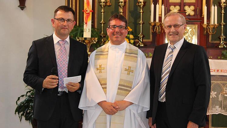 Kirchenpfleger Gebhardt (l.) und Bürgermeister Sendelbeck verabschieden Pfarrer Wolf,