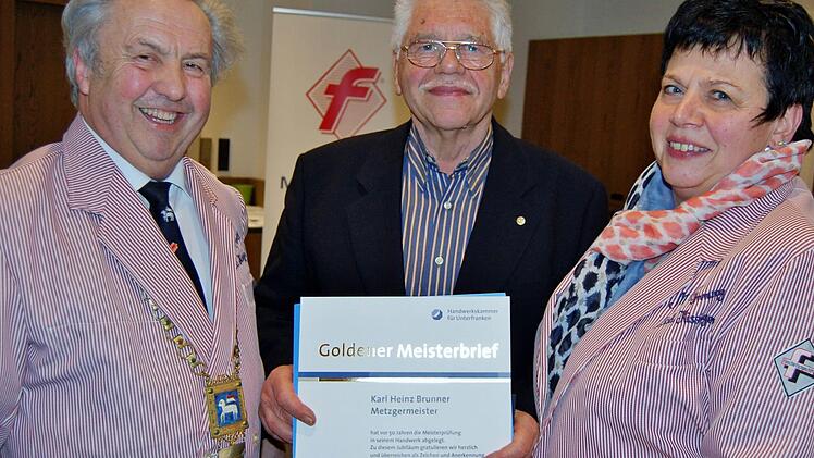 Innungsobermeister Robert Schmitt (links) und seine Stellvertreterin Sabine Klöffel überreichen dem Bad Kissinger Metzgermeister Karl Heinz Brunner den goldenen Meisterbrief zum 50-jährigen Meister-Jubiläum.  Foto: Sigismund von Dobschütz