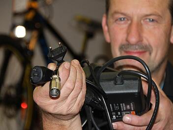 Je nach Anbieter: Gernot Riemey zeigt unterschiedliche Steckverbindungen für Fahrrad-Akkus. Meistens haben Radler ihr Ladekabel dabei und benötigen nur noch eine herkömmliche Steckdose. Foto: Ulrike Müller