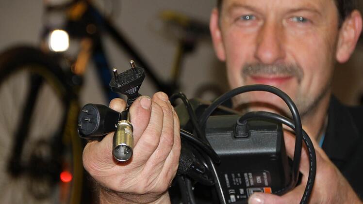 Je nach Anbieter: Gernot Riemey zeigt unterschiedliche Steckverbindungen für Fahrrad-Akkus. Meistens haben Radler ihr Ladekabel dabei und benötigen nur noch eine herkömmliche Steckdose. Foto: Ulrike Müller