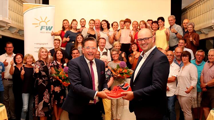 Für den Weg bis zu den Wahlen bekam Karsten Fischkal (l.) orangefarbene Laufschuhe von Tim Scheppe überreicht.   Foto: Johanna Blum