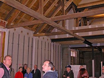 Interessierte Bürger, Bürgermeister Michael Keilich (links), Altbürgermeister Rainer Marr und der Bauausschuss ließen sich vom Architekten Harald Gasmann Fortschritte beim Domänenumbau erläutern. Von der künftigen Veranstaltungshalle aus schafft die erhalten gebliebene Dachkonstruktion freie Sicht bis unters Dach. Foto: Klaus Oelzner