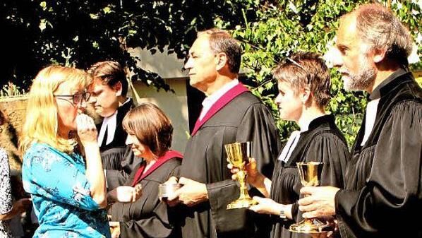 Pfarrer Dieter Grimm, Pfarrerin Claudia Winterstein (von rechts) sowie Pfarrer Peter Hohlweg (Fünfter von rechts) beim Feiern des Abendmahls mit den Gläubigen Fotos: Günther Geiling