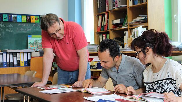 Karl-Friedrich Krohm (links) unterrichtet Karimi Shir Ali und seine Frau Mansoureh Naroozi in einem Alphabetisierungskurs.  Fotos: Julia Raab