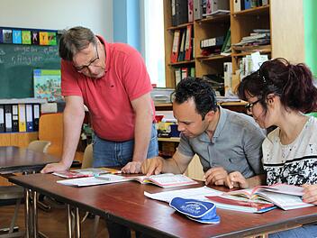 Karl-Friedrich Krohm (links) unterrichtet Karimi Shir Ali und seine Frau Mansoureh Naroozi in einem Alphabetisierungskurs.  Fotos: Julia Raab