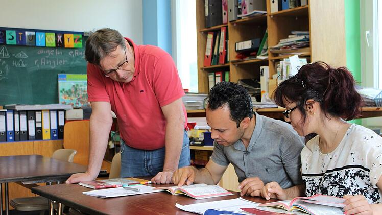 Karl-Friedrich Krohm (links) unterrichtet Karimi Shir Ali und seine Frau Mansoureh Naroozi in einem Alphabetisierungskurs.  Fotos: Julia Raab