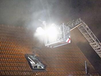 Die Einsatzkräfte der Feuerwehr entfernten Dachziegel, um an den Brandherd zu gelangen. Ein technischer Defekt an einem stromführenden Kabel hat laut Polizei den Brand ausgelöst.  Foto: Michael Stelzner