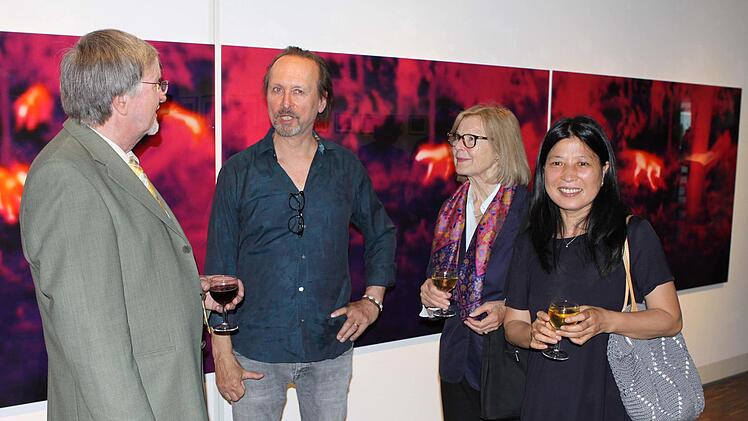 Der Kölner Stephan Reusse (Zweiter von links) im Gespräch mit dem Vorsitzenden des KKV Karol J. Hurec (links). Mit im Bild weitere Besucher der Ausstellungseröffnung, vor einen seiner Bilder. Foto: Michael Wunder