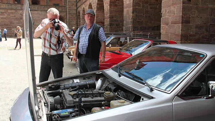 Oldtimer-Fans sind technikbegeistert. Michael Fischer aus München entdeckt im Alfa Romeo von Axel Vogelsang aus Kühlungsborn (rechts) einen Doppelnockenwellenmotor. Mit seiner Kamera fotografiert er ihn.