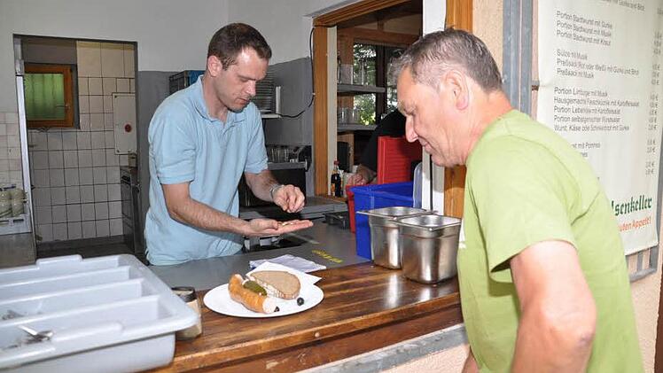 Braumeister Andreas Geyer (l.) arbeitet auf dem Keller auch an der Essensausgabe mit.