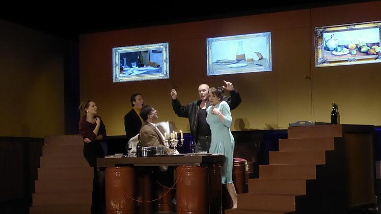 Und am Ende, vor dem großen Knall, laden Gottfried Biedermann (Marc Marchand) und seine Frau Babette (Susanne Pfeiffer) die beiden Brandstifter Schmitz (Alexander Bräutigam, rechts hinten) und Eisenring (Benjamin Jorns, links hinten) zum Festmahl mit Gänsebraten auf den Benzinfässern ein, weil sie glauben, dass man sich sie zu Freunden machen muss, um die Gefahr zu bannen, was lediglich das Dienstmädchen Anna (Anna Schindlbeck, ganz links) bezweifelt.  Foto: Thomas Ahnert