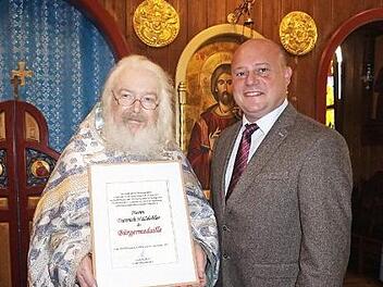 Bürgermeister Georg Seiffert verlieh an Pfarrer Fjodor Hölldobler die Bürgermedaille der Stadt Bischofsheim.  Foto: Marion Eckert