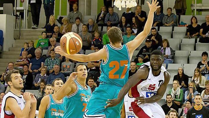 Die Coburger Basketballer (weiße Trikots) spielten mit den Würzburgern Katz und Maus. In dieser Szene bereitet Nicolau Dilukila (Nummer 12) hinter dem Rücken des Würzburgers einen Korb vor. Foto: Albert Höchstädter