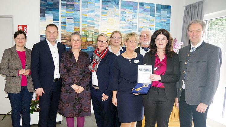 Das Bild zeigt (von links) 2. Bürgermeisterin Angela Hofmann, Sabine Lesch (stellvertretender Vorstand), MdL Jürgen Baumgärtner, Melanie Beitzinger, Heimleiterin Karin Büttner, stellvertretende Dekanin Kristine, Wachter, Karin Pfadenhauer (Vorstand), Heimleiter Roland Rost, Landrat Klaus Löffler. Heike Schülein