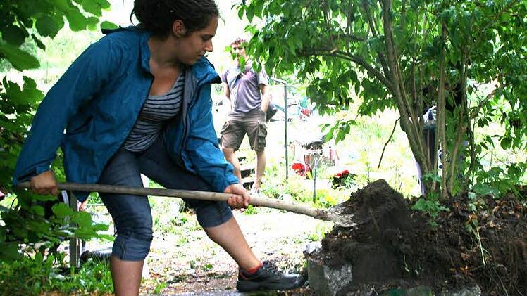 Sophie pflanzt einen Baum um, damit Rollstuhlfahrer in Zukunft besser in den Garten können.  Fotos: Daniela Pondelicek