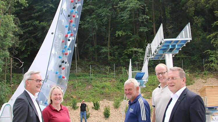 Links ist die Kletterwand, im Hintergrund der Sprungturm zu sehen. Unser Bild zeigt (von links) Stadtwerke-Leiter Stephan Pröschold, Stadtförsterin Carmen Hombach, Rainer Foltes vom  Freibad,  Oliver Voss von den Stadtwerken, und OB Henry Schramm. Foto: Alexander Hartmann
