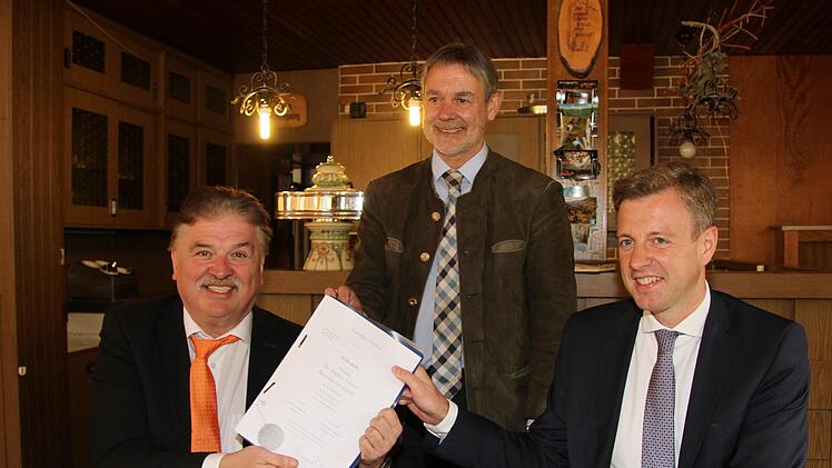 Mit großer Freude präsentieren die Landräte (vorne, von links) Klaus Peter Söllner aus Kulmbach und Oliver Bär aus Hof sowie der stellvertretende Landrat Gerhard Wunder aus Kronach (stehend) den Kaufvertrag.