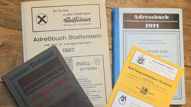 Spaß macht die Lektüre alter Staffelsteiner Adressbücher (von links im Uhrzeigersinn) aus den Jahren 1957, 1967, 1971 und 1950. Foto: Matthias Einwag