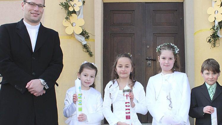 Unterhohenried — Einen feierlichen Erstkommunions-Gottesdienst feierten in Unterhohenried (von links) Anna Fuchs, Mona Schneider, Leonie Linsner und Bastian Geuppert (alle Sylbach) zusammen mit Haßfurts Kaplan Manuel Vetter (links). Foto: Ralf Naumann