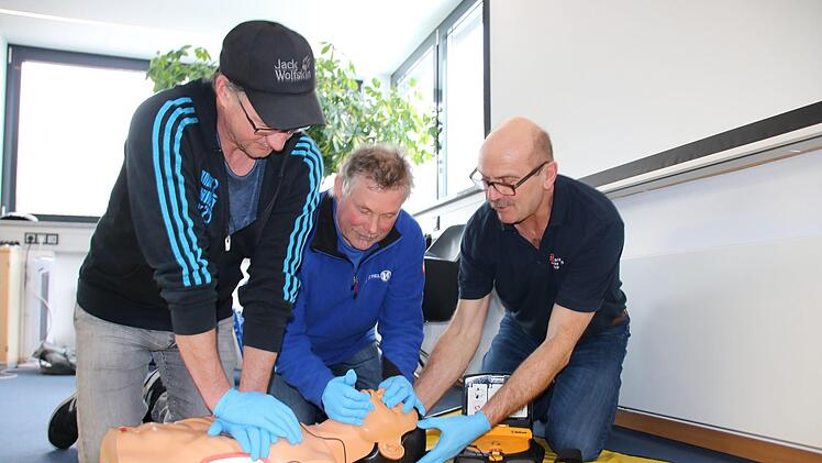 Unter Anleitung von Rettungsassistent Uve Bartz (rechts) üben Frank Keidel und Ulf Wagner an einer Puppe die Herz-Lungen-Wiederbelebung: 30 Mal drücken, dann zwei Atemstöße. Foto: Ralf Ruppert