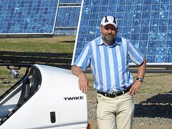 Hans-Josef Fell im Jahr 2005 mit seinem Twike in Arnstein am damals weltgrößten Solarpark. Foto: Archiv Fell