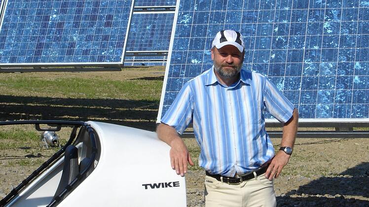 Hans-Josef Fell im Jahr 2005 mit seinem Twike in Arnstein am damals weltgrößten Solarpark. Foto: Archiv Fell