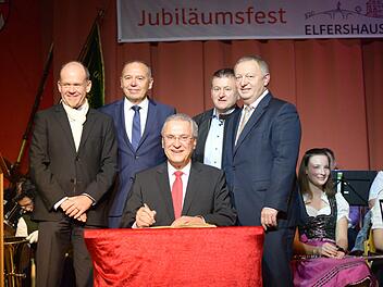 Bayerns Innenminister Joachim Hermann ist Schirmherr des 1200-jährigen Jubiläums von Elfershausen. Bei seinem Besuch zum Eröffnungsabend des Jubiläums trägt er sich ins Goldene Buch der Gemeinde ein. Foto: Melanie Edelmann