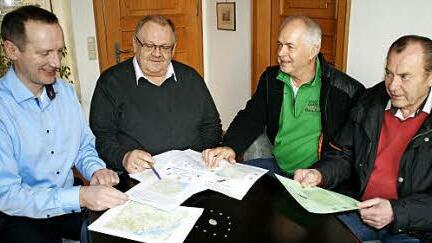 B&uuml;rgermeister Michael Ziegler, Edgar Geisel, Udo Rhein und Horst Urban (von links) besprechen die Wanderrouten im Steigerwald.  Foto: sw